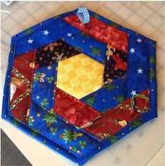 a close up of a patchwork hexagonal object on a table