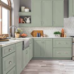 a kitchen filled with lots of green cabinets