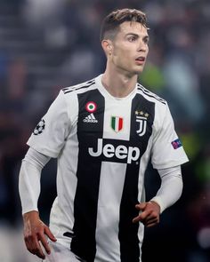 a soccer player in black and white uniform with his hand on his hip looking to the side