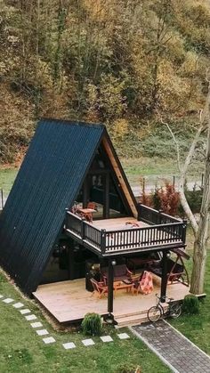 a small house with a porch and deck in the grass