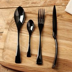 four forks, two spoons and one knife on a cutting board