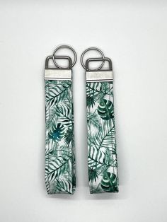 Tropical Greenery / Monstera Fabric Key Fob Keychain Wristlet  1" wide silver metal key fob hardware and key ring. Fabric Design or Colors: greenery on white background  Length of wristlet approximately  (from top of hardware to bottom)  Regular: 4" ( 3.25" loop opening )  **Each key chain design is cut from larger fabric prints. Each Keychain will be unique and may vary slightly from pictures seen, depending on which area of fabric "makes the cut" for your personal key chain.  All Key chains in White Adjustable Wristlet With Key Leash, Adjustable White Wristlet With Key Leash, Trendy Green Rectangular Wristlet, Adjustable Green Rectangular Wristlet, Green Adjustable Rectangular Wristlet, Monstera Fabric, Fabric Key Fob, Fabric Keychain, Tropical Greenery