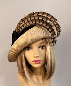 This couture hat was handmade on an antique hat block using a parasisal straw. This lovely cloche hat is embellished with silk dupioni and Lady Amherst Pheasant Tail Feather Please indicate your head size measurement when ordering (measure your head horizontally just above your eyebrows). When you receive your hat, there will be a small ribbon inside to fine-tune the fit, and a hat box for safe storage. Note: Colors will vary depending on your monitor and there will also be some variations due t Feather Embellishment, Custom Made Hats, Pheasant Feather, Hand Dyed Silk Ribbon, Couture Hats, Silk Dupioni, Hat Blocks, Antique Hats, Pheasant Feathers