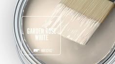 a paint can with white paint and a brush in it that says garden rose white