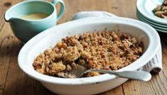 a white bowl filled with food on top of a wooden table