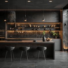 a kitchen with black cabinets and counter tops is lit by pendant lights that hang from the ceiling