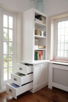 an empty room with bookshelves, window and radiator