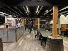 people are walking through an empty restaurant with tables and chairs