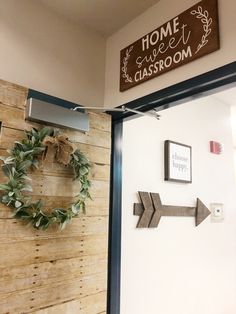 the front door to a classroom with a wreath on it and an arrow hanging from the wall