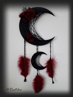 the moon is decorated with red feathers and flowers on it's side, along with other decorations