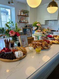 a kitchen counter topped with lots of different types of foods and desserts on top of it