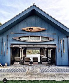 a blue building with a surfboard on the roof and two benches in front of it