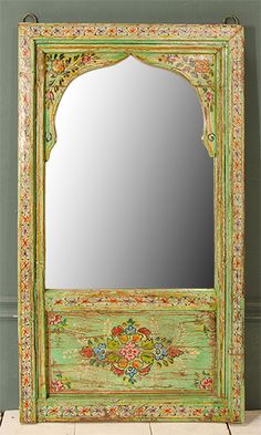 an ornate green mirror sitting on top of a tiled floor