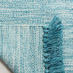 a blue and white rug with fringes on it