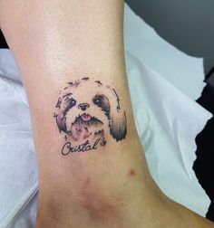 a small dog tattoo on the ankle that says crystal in cursive font and an image of a shih tzug