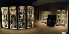 a room filled with lots of different types of figurines in glass cases next to a flat screen tv