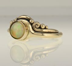 Ethiopian Opal Ring/ Gold Opal Ring/ Colorful Opal Ring/ Gift For Her/ Minimalist Gold Ring/ Handmade One of a Kind/ October Birthday R1119- 14k Yellow Gold Ring with 7 mm Colorful Ethiopian Opal Cabochon. *The stone is not set yet to make it easier to size without damaging the stone*. So you can request a different stone since this one isn't set yet. The top of the ring measures 10 mm Wide and the band is 2 mm wide. It is a size 7 3/4 and can be sized down for Free. Small fee for sizing up, ple Handmade Yellow Gold Opal Ring, Handmade 14k Gold Opal Ring, 14k Gold Art Nouveau Round Ring, Luxury Handmade Ethiopian Opal Ring, Handmade Gold Opal Ring With Ethiopian Opal, Handmade Ethiopian Opal Rings, Gold Ethiopian Opal Cabochon Ring, Unique Ethiopian Opal Cabochon Rings, Swiss Blue Topaz Ring