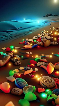 the beach is filled with many different colored rocks and pebbles, all lit up at night