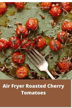 a green plate topped with lots of red tomatoes next to a fork and some olives