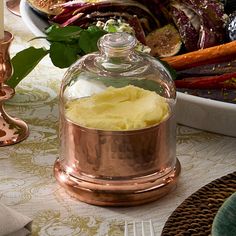 a table topped with lots of food next to a vase filled with yellow cake frosting