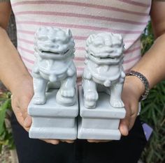 two white foo foo statues held in their hands