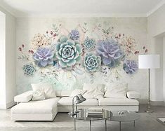 a living room with white furniture and flowers on the wall