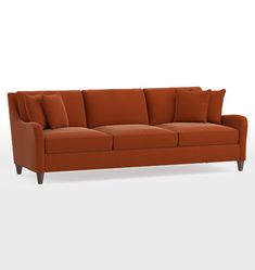 an orange couch with two pillows on the back and one arm folded out to show it's shape