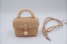 a straw bag with wooden beads on the handle and a lanyard attached to it