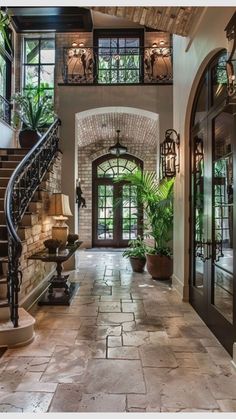 an entry way with stairs, potted plants and glass doors that lead to the second floor