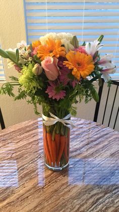 a vase filled with flowers on top of a wooden table