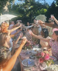 a group of people sitting around a table with plates and cups