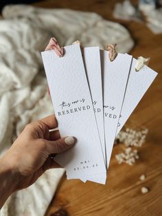 someone holding up some white cards with writing on them