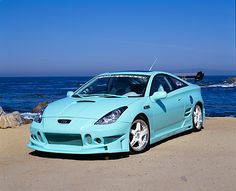 a blue sports car parked on the beach