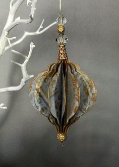 an ornament hanging from a tree branch with white branches in the foreground