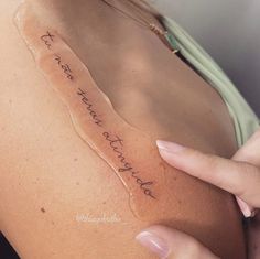 a woman is holding her arm with writing on it