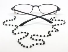 "!! EXPRESS SHIPPING IS AVAILABLE !! Check our SHOP for more fabulous designs:  https://www.etsy.com/ca/shop/KalxDesigns Jet black Czech glass beads on individual links give this eyeglasses chain a beautiful and soft drape.  Perfect for your reading glasses or sunglasses.The glasses chain is complemented by clear eye glass loops with a pretty silver slider which provides a nice snug fit on your eyeglasses arms.   Length: 27\" Color: Black and silver Materials: Czech glass beads, eyeglass arm loo Elegant Glass Beaded Necklace With Adjustable Chain, Elegant Glasses Chains With Lobster Clasp, Elegant Glasses Chains With Single Strand Round Beads, Elegant Adjustable Beaded Glasses Chains, Elegant Single Strand Glasses Chains With Round Beads, Adjustable Black Beads Glasses Chains For Gift, Adjustable Black Beads Glasses Chains As Gift, Elegant Adjustable Glasses Chains With Round Beads, Handmade Elegant Glasses Chains With Round Beads