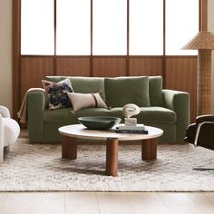 a living room with green couches and white rugs on top of a wooden floor