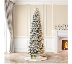 a white christmas tree in a living room with gold trimmings and presents on the floor