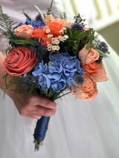 a person holding a bouquet of flowers in their hands and wearing a wedding dress with an orange, blue, and white color scheme