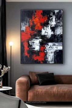 an abstract painting hangs on the wall above a couch in a living room with black and red accents