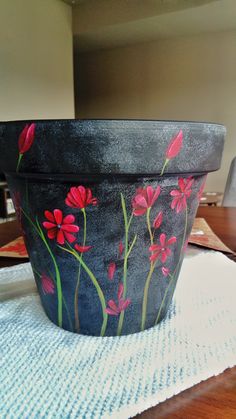 a painted flower pot sitting on top of a table