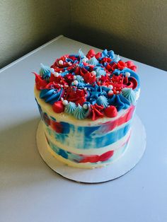 a cake with red, white and blue frosting sitting on top of a table