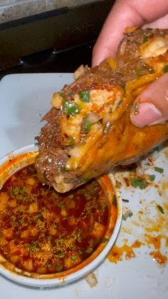 a person is dipping some food into a bowl