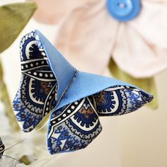 an origami butterfly sitting on top of some flowers