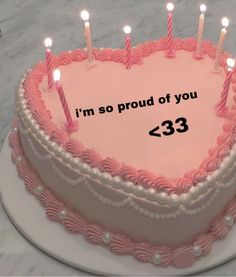 a heart shaped cake with candles on it that says i'm so proud of you