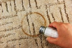 a person is spray painting the carpet with white paint on it and holding a bottle in their hand