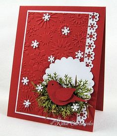 a red card with white snowflakes and a wreath