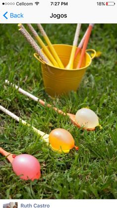 two buckets filled with eggs sitting in the grass next to an orange and white cup