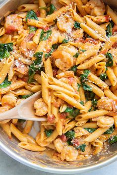 pasta with chicken, spinach and parmesan cheese in a pan