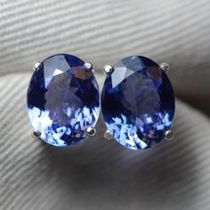 These tanzanite earrings feature a well matched pair of genuine earth mined tanzanite. The earrings are made of solid sterling silver. The tanzanite are described as follows:Natural Zoisite/TanzaniteOrigin: Merelani, Northern TanzaniaCarat Weight: 2.75cts + 2.89cts = 5.64cts total weightShape: Oval Mixed CutMeasurements: 9.99mm x 7.85mm x 4.83mm and 10.19mm x 8.00mm x 4.73mm*** Bridal Party Jewelry Sets, Birthstone Necklace Mothers, Tanzanite Studs, Sapphire Stud Earrings, Blue Sapphire Studs, Silver Bridesmaid, Tanzanite Earrings, Sapphire Earrings Studs, Unique Jewelry Gifts